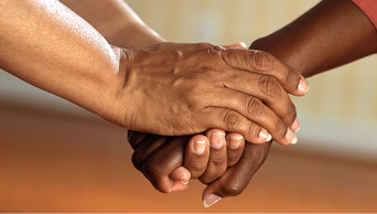 close up of two black individuals holding hands