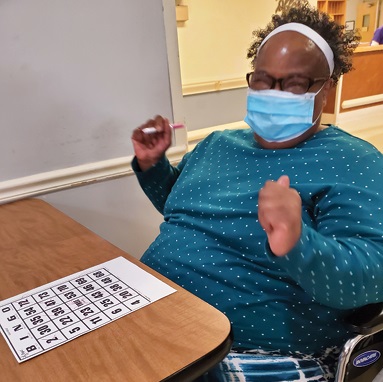 Woman sitting in chair at table playing BINGO