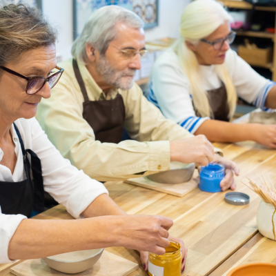 a group of people participating in a pottery class together